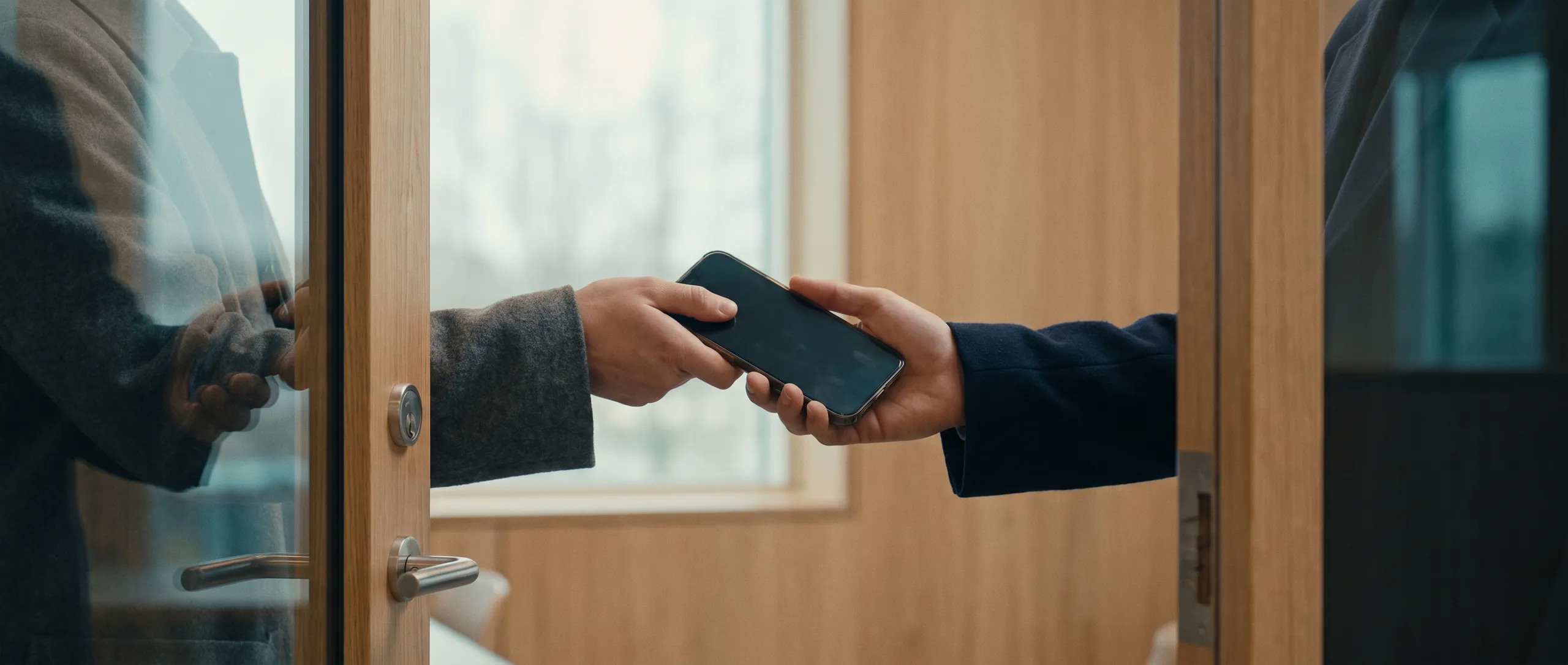 A phone being handed over at an office door